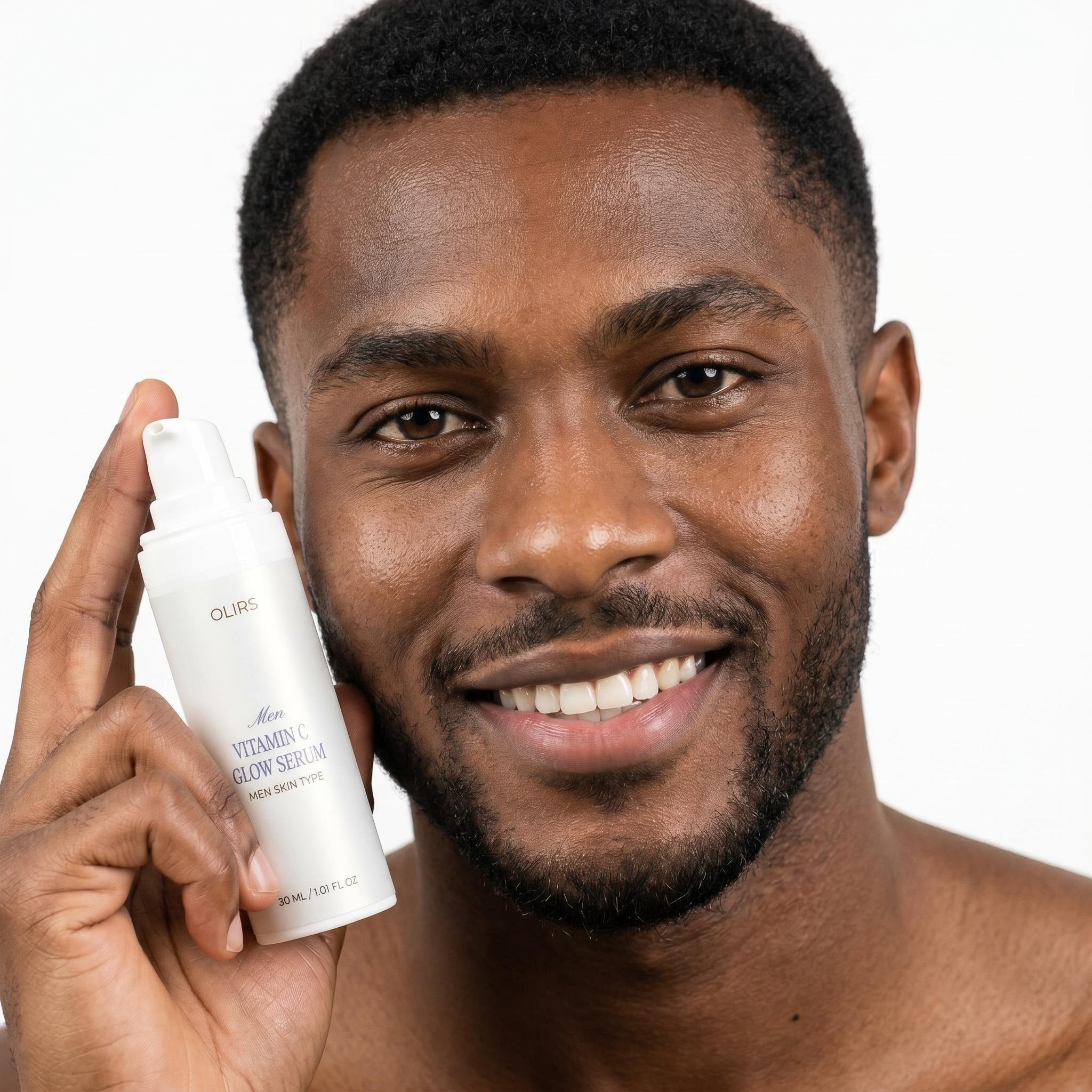 Man smiling while holding the Men Vitamin C Glow Serum from Even-Tone Routine Duo for brighter-looking skin.