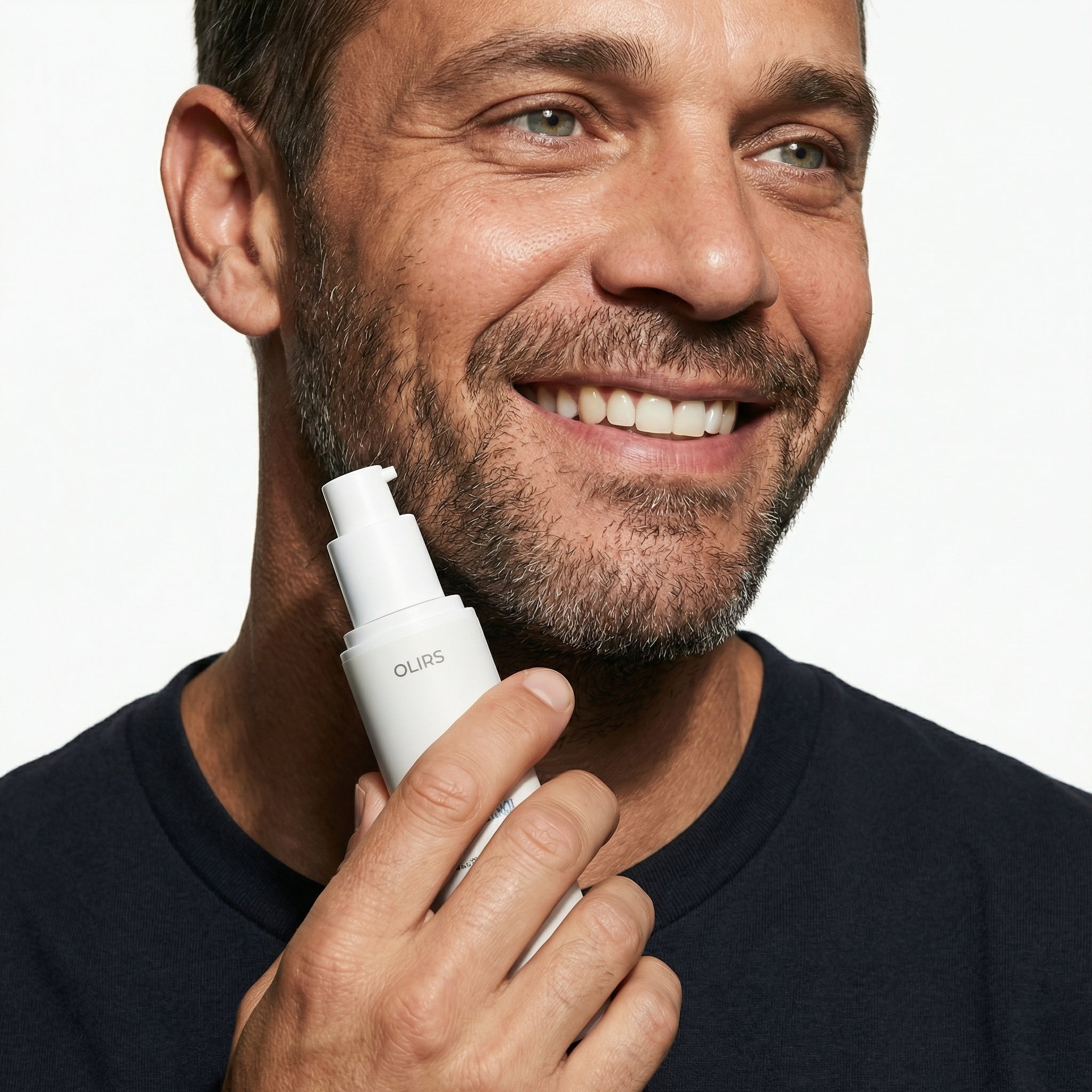 Man holding Advanced Night Renewal Serum, smiling and showcasing skincare routine for smoother-looking skin.