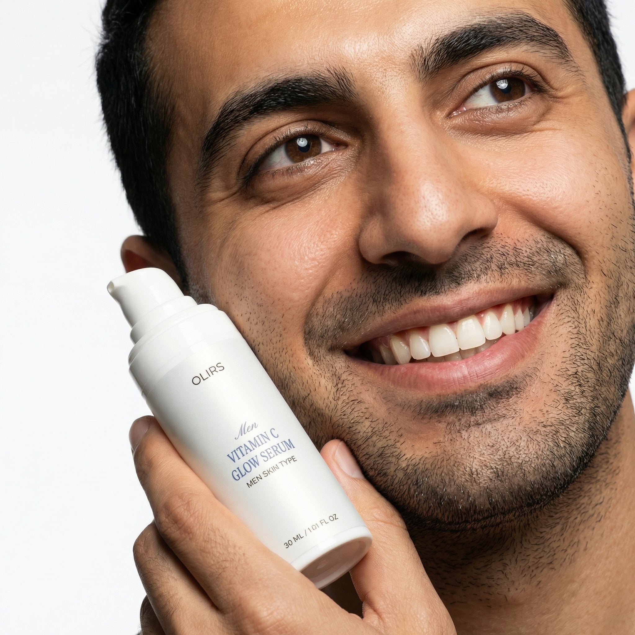 Man smiling while holding Men Vitamin C Glow Serum for brighter-looking, hydrated skin.