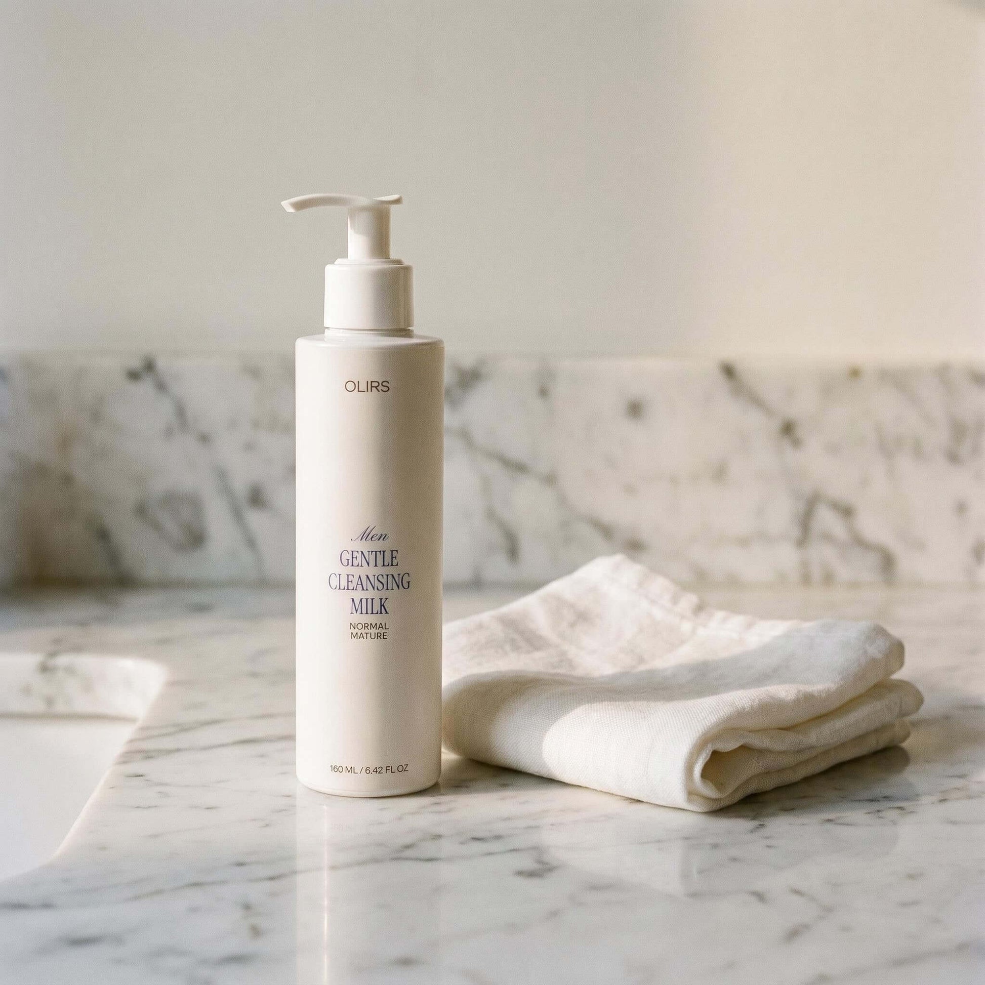 Gentle Cleansing Milk bottle on marble surface with soft cloth, highlighting organic skin care for sensitive skin.