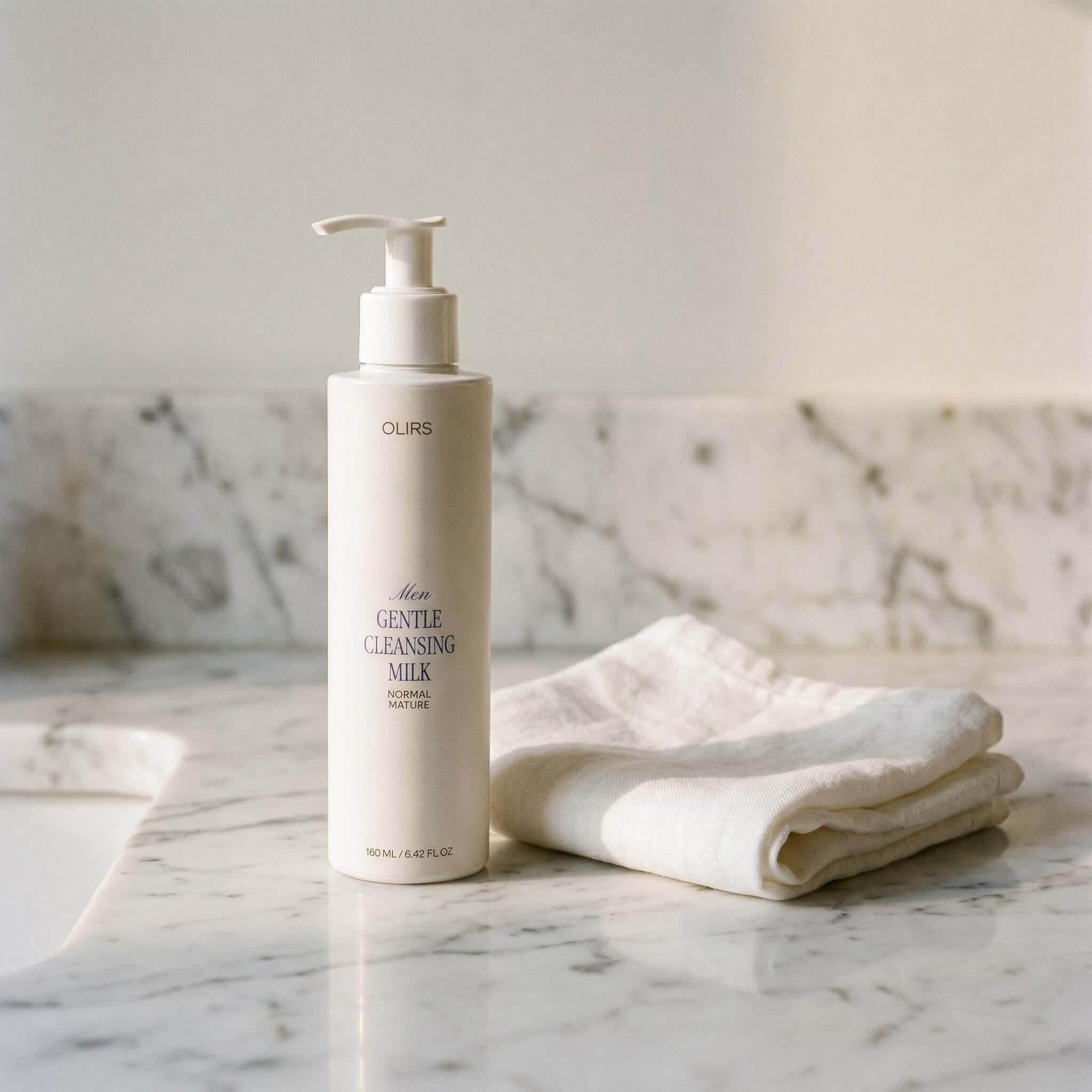 Gentle Cleansing Milk bottle on marble surface with soft cloth, highlighting organic skin care for sensitive skin.