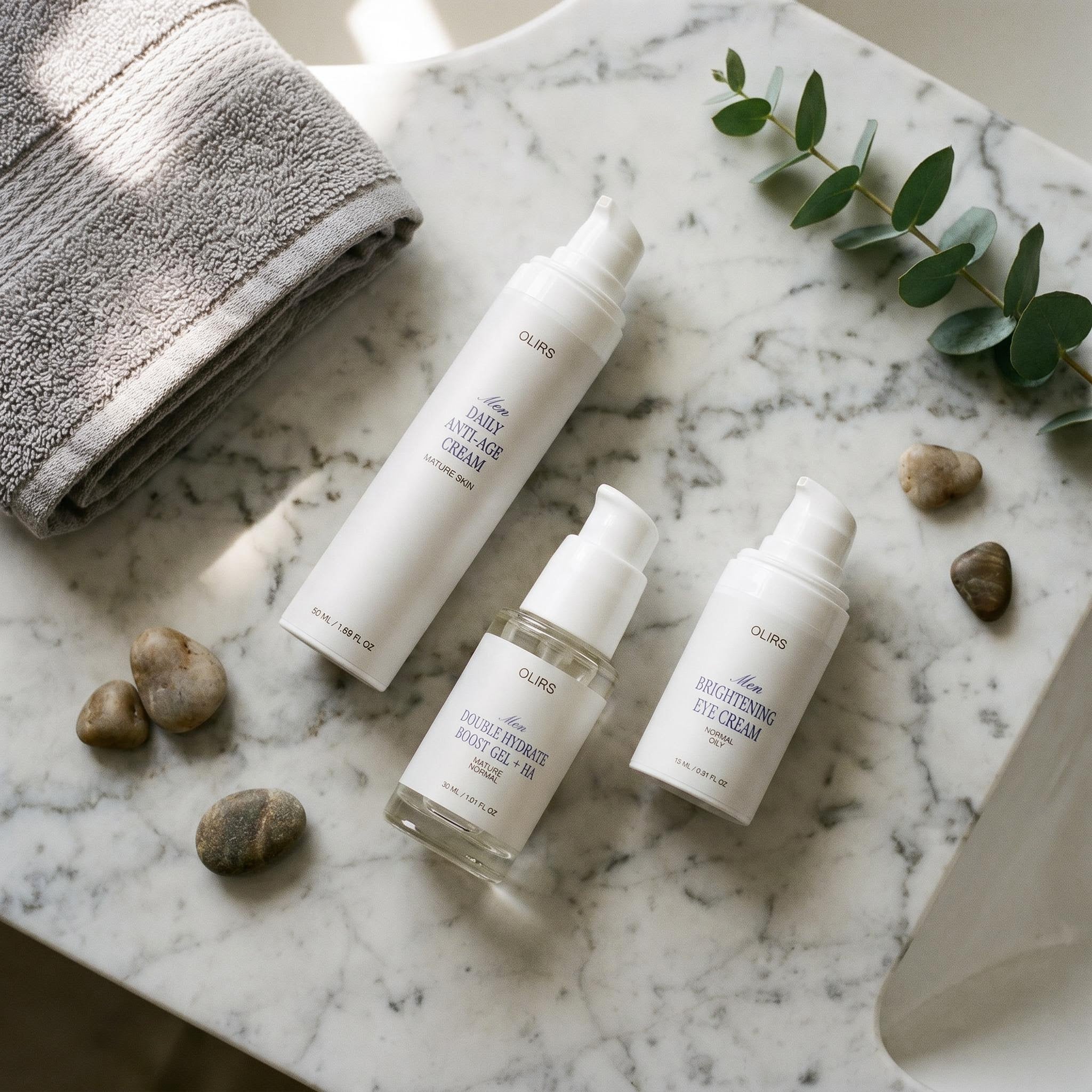 Deep Moisture Trio skincare products displayed on a marble countertop with stones and a towel.